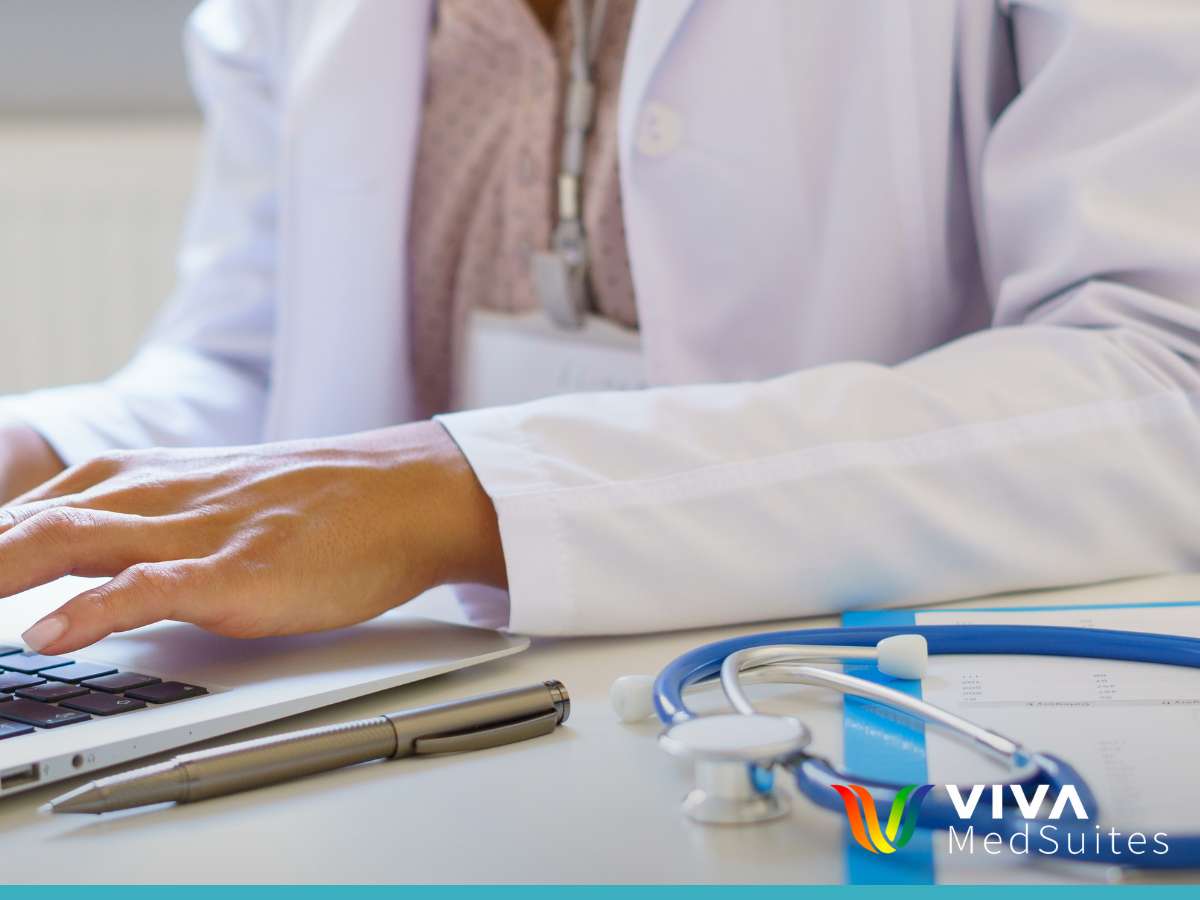 Doctor working on a laptop with stethoscope and pen on desk in a Medical Coworking Space